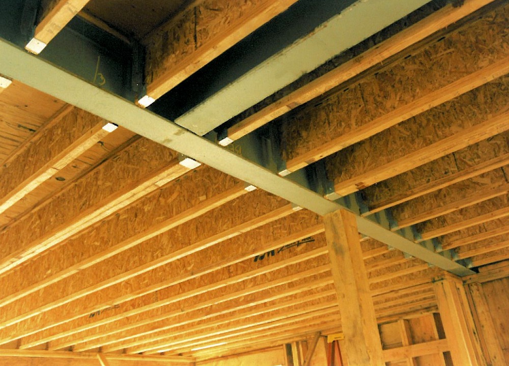 Construction phase - steel i-beams recessed in ceiling to pick up point loads from above custom homes by Rick Bernard.