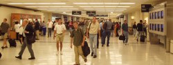 Looking back at other gates and the row of monitors in bright airport