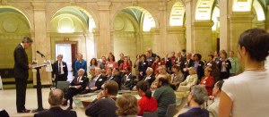 People seated in a room with lots of arches listening