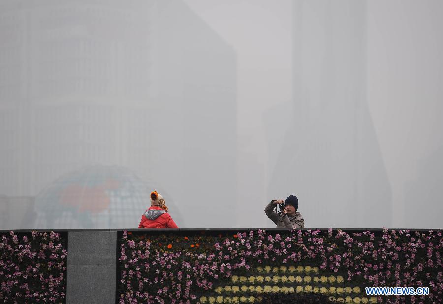 Tourists visit the Bund in the fog in east China's Shanghai Municipality, Jan. 24, 2013. Fog hit Shanghai Thursday. (Xinhua/Lai Xinlin) 

