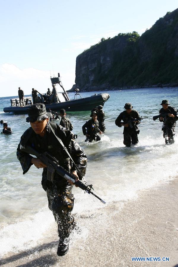 Philippine Military Academy (PMA) cadets take positions ashore during a joint field training exercise at the Marines' training centre in Cavite Province, the Philippines, May 29, 2013. More than 700 future military officers in the Philippines went through drills at a marine base for joint training on land, air, and sea assault after seven marine soldiers were killed in action in a clash against Islamist militant members of the al-Qaeda-linked Abu Sayyaf in Patikul town in Sulu, southern Philippines on May 25. (Xinhua/Rouelle Umali) 

