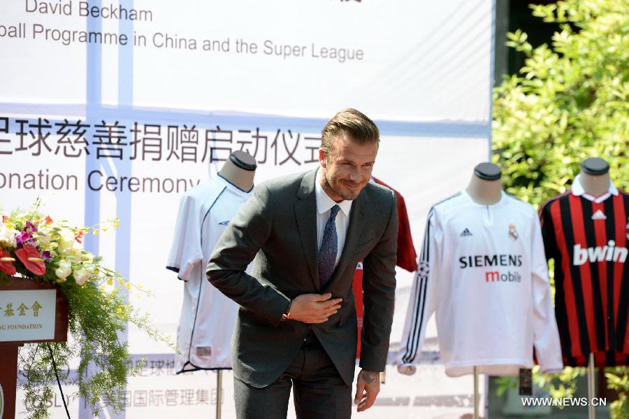 Recently retired football player David Beckham takes a bow during a donation ceremony in Beijing, capital of China, June 17, 2013. As the ambassador for the Football Programme in China and China's Super League, Beckham donated various team jerseys he wore during his career to a children's charity in China. David Beckham is joined by his wife Victoria during a seven day visit in China starting today. (Xinhua/Guo Yong) 
