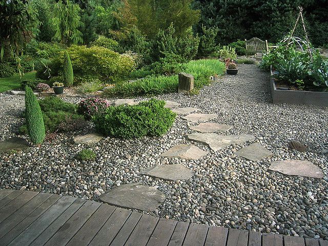 gravel patio -- love to do something similar under the deck, with flagstone path and plants around the edges -- would so help with drainage, too...