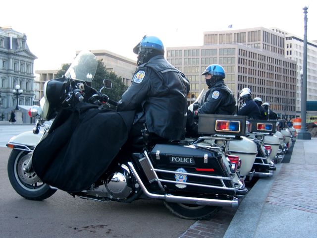 A string of DC's finest waits on their sidecar-equiped Harleys outside the White House gates on Pennsylvania Ave.