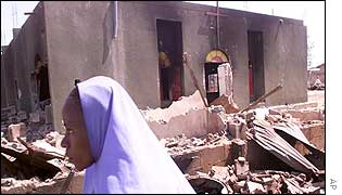 A woman walks past a burnt-out church