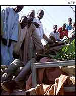 Crowd around a truck laden with coffins