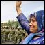 A Muslim ethnic Uighur woman gestures toward Chinese riot police 