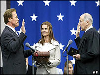 Schwarzenegger (left) is sworn in by Chief Justice Ronald George (right), with the actor's wife Maria Shriver (centre) looking on