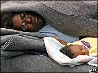 Mother sleeps with her young baby in Astrodome, Houston, Texas