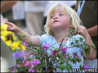 A young Swedish girl points out a photograph on a memorial wall during a memorial service at Mai Khao, Thailand