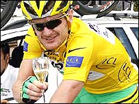 Floyd Landis drinks a glass of champagne on the final stage into Paris