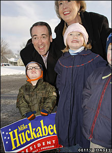 Mike Huckabee poses with a supporter and her family in Warren, Michigan