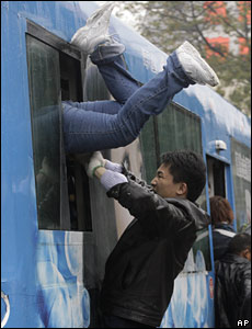 A man pushes a woman into a bus which will take them to the Guangzhou Railway Station, China (30/01/2008)