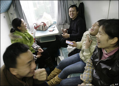 Passengers smile after getting on a train at Guangzhou Railway Station, China (30/01/2008)