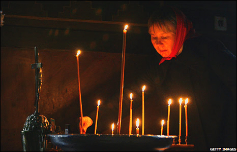 Russian worshipper lights a candle in a Moscow church