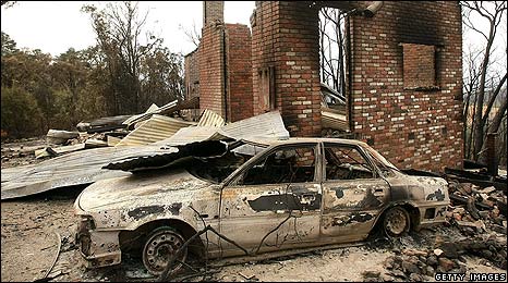 A burned out car and house following bushfires in Christmas Hills, Australia