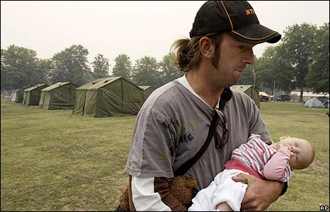 Sean Galpin carries his three-month-old daughter, Lucy, at a relief centre in Yea