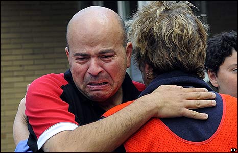 A survivor is consoled by a Country Fire Authority member outside the Healesville Relief Centre