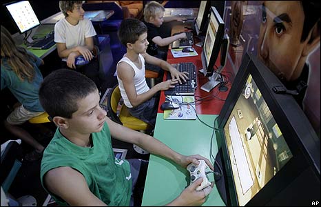 Tony Petkovski (L) and his brother Mark (C) play video games in a mobile youth centre bus at Yea