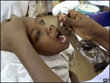 A health worker gives a child an oral polio vaccine in Kano, Nigeria