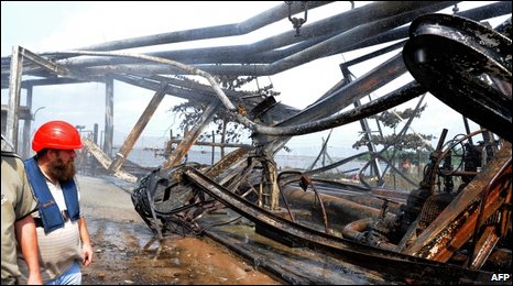 Workers examine wrecked oil pipelines at the Atlas Cove Jetty Depot.