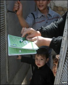 An Iraqi woman hands in her voting paper, 2 April 2010