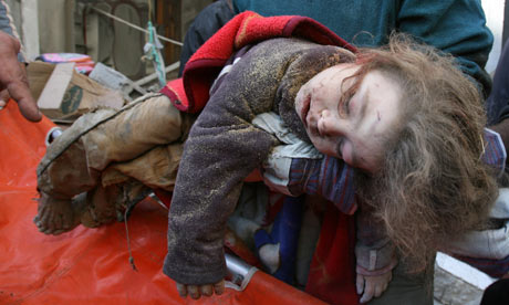 The body of a child is removed from a house in Zeitun