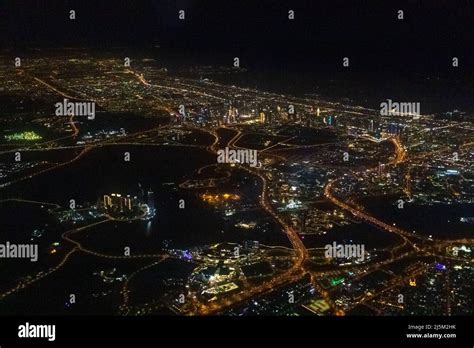 Night view of Dubai Skyline seen from flying plane above Persian Gulf ...