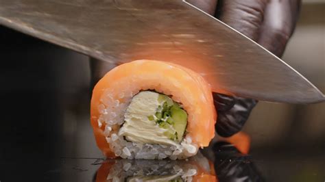 Chef Slices sushi on the sushi bar. Preparing sushi nigiri fish ...