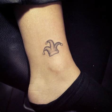 Ankle tattoo of a jester hat, by Murat Bilek.