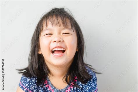 Happy Little asian girl child showing front teeth with big smile and ...