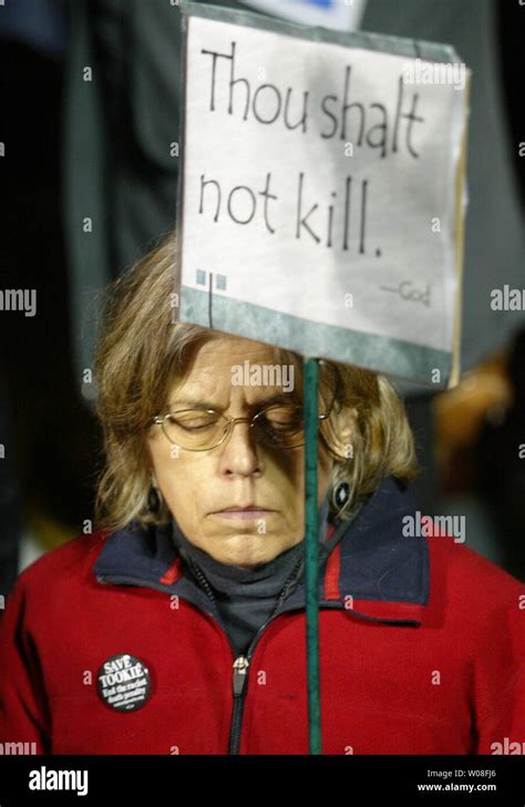 A woman prays outside San Quentin Prison where Stanley "Tookie ...