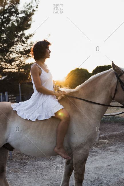 Barefoot woman riding bareback on horse stock photo - OFFSET