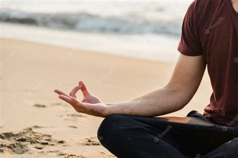 Premium Photo | Man practicing yoga on the beach