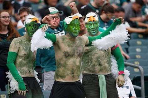 two men with green and white paint on their faces are standing in front ...