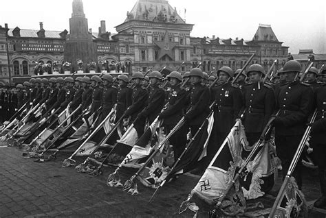 Red Army soldiers carry captured Nazi flags inverted towards the ground ...