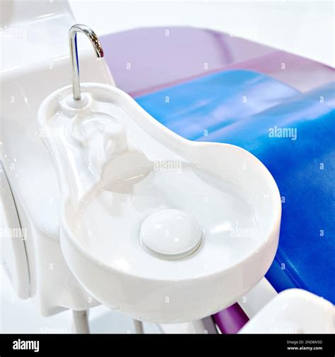 Dental spittoon near medical chair Stock Photo - Alamy