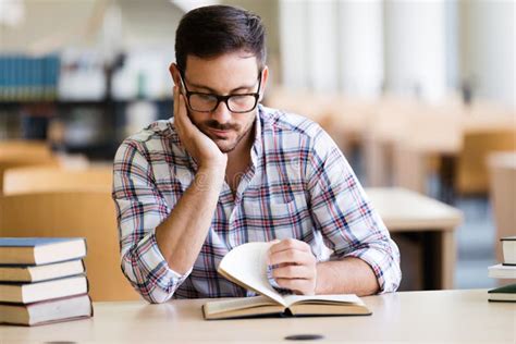 Serious Male Student Reading Book in the College Library Stock Photo ...