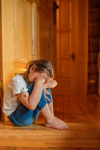 Premium Photo | A little girl cries sadly hiding at home the child is ...