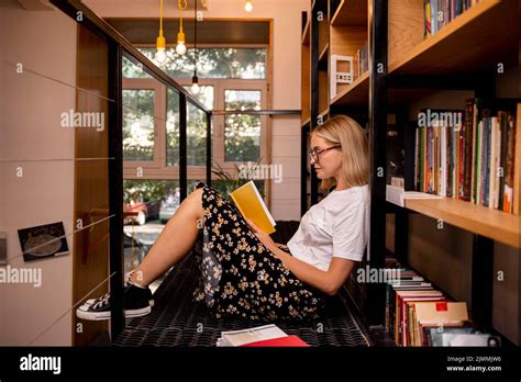 Student reading book library Stock Photo - Alamy