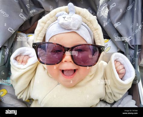 Funny face of baby girl is laughing in sunglasses. Cute baby with ...