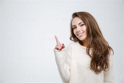 Smiling young woman pointing finger up 1258193 Stock Photo at Vecteezy