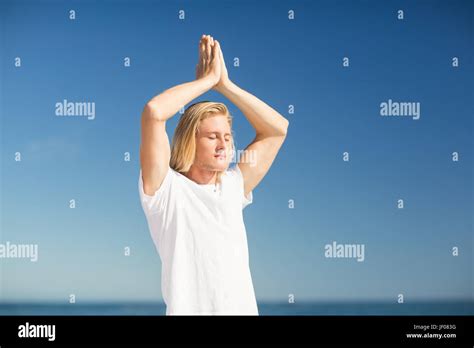 Man performing yoga on beach Stock Photo - Alamy