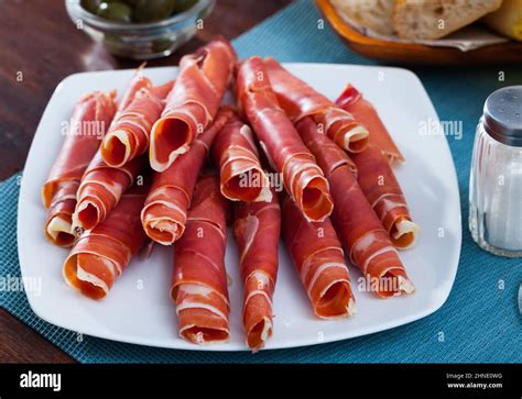 Dry-cured ham slices on white platter Stock Photo - Alamy