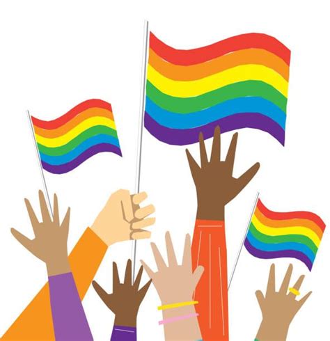 people raising rainbow flags in the air with their hands up