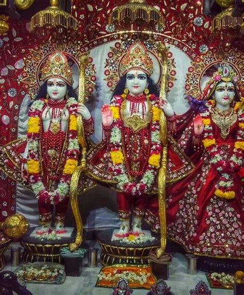 two statues of hindu deities in front of a red and white backdrop with ...