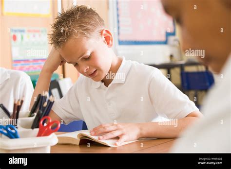 Student in class reading book Stock Photo - Alamy