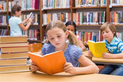 Cute Pupils Reading in Library Stock Photo - Image of male, childhood ...