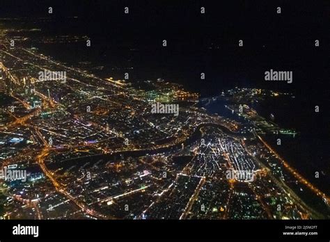 Night view of Dubai Skyline seen from flying plane above Persian Gulf ...