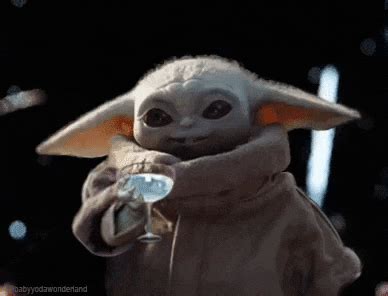 the child yoda is holding something in his hands and wearing a star ...